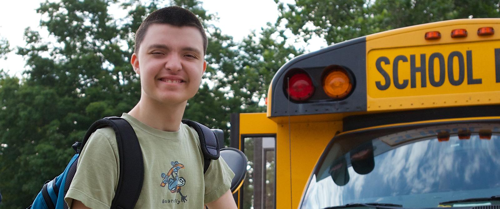 Male Student arrives at Midland School on School Bus